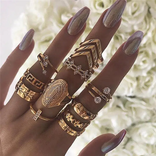 Hand adorned with various gold rings, showcasing a stylish collection of statement and delicate designs.