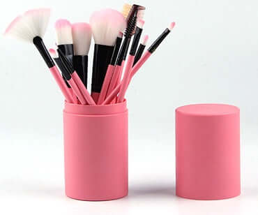 12-piece professional makeup brush set displayed in a pink barrel box, showcasing various brush types for beauty application.