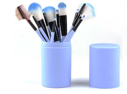 12-piece professional makeup brush set in a blue barrel box, featuring various brush types for flawless application.