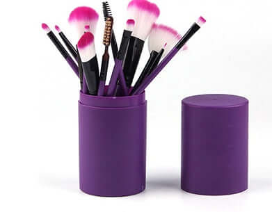 12-piece professional makeup brush set in purple barrel box with pink bristles.