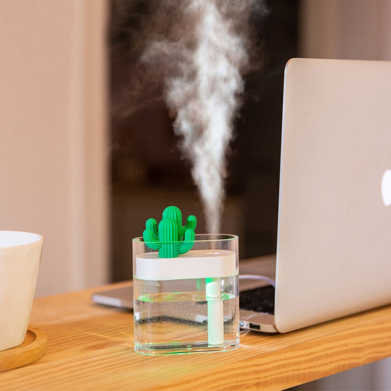 160ML ultrasonic air humidifier with cactus design, creating mist next to a laptop on a wooden table.